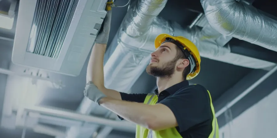 An HVAC technician installing a new air conditioning system in a commercial building